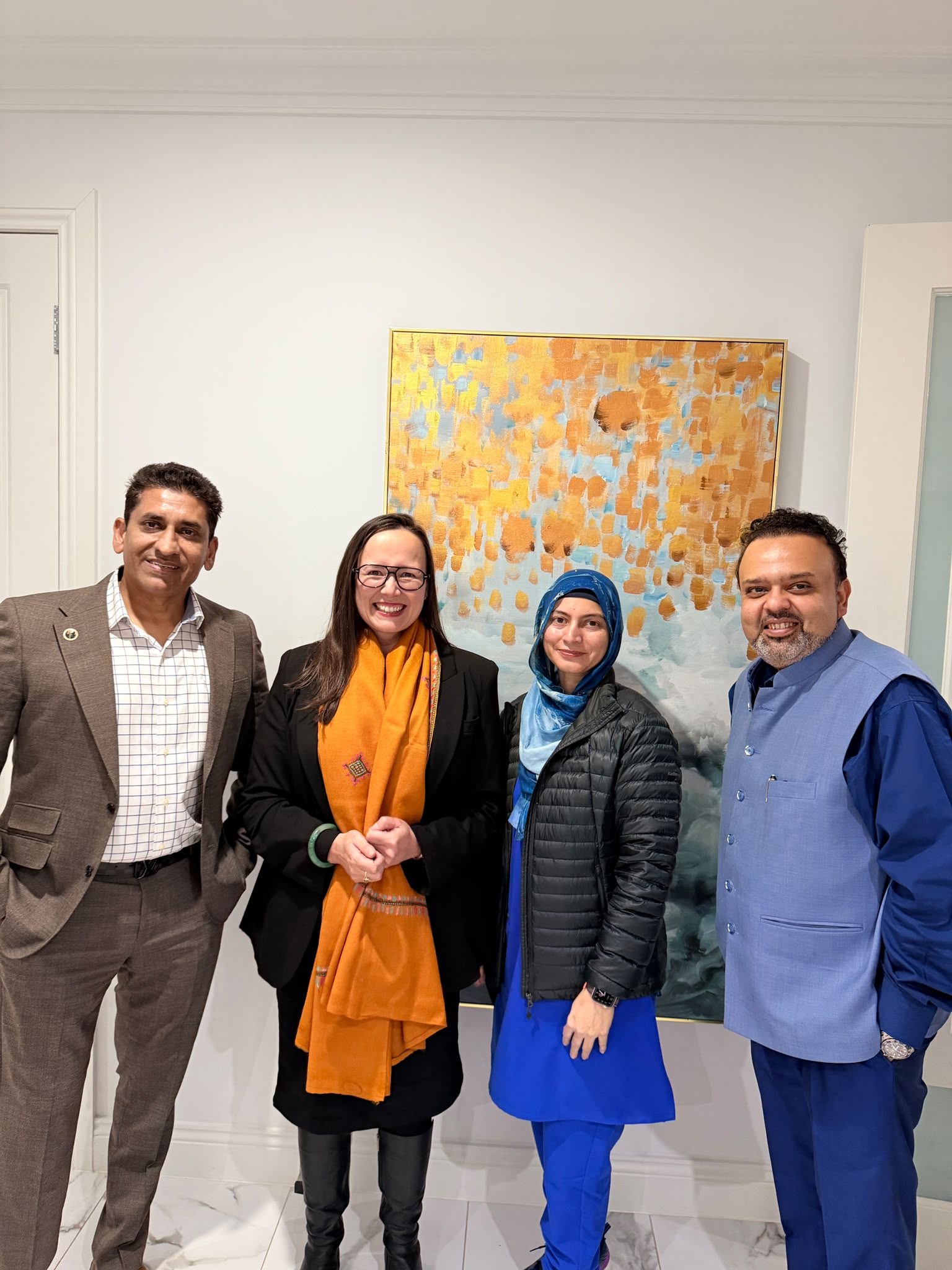 Doctors at Cranbourne West Medical Centre standing at reception with the clinic logo wall